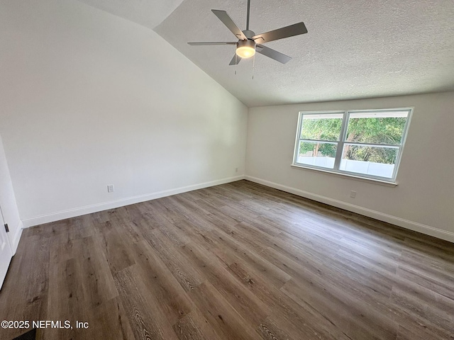 946 Cedar Ridge Ct, Orange Park, FL 32065 - empty room with vaulted ceiling, ceiling fan, dark wood finished floors, baseboards, and a textured ceiling