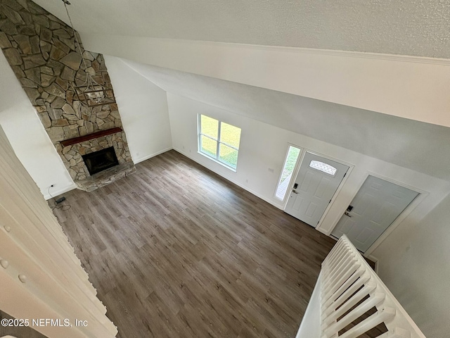 946 Cedar Ridge Ct, Orange Park, FL 32065 - unfurnished living room with lofted ceiling, wood finished floors, a fireplace, baseboards, and a textured ceiling