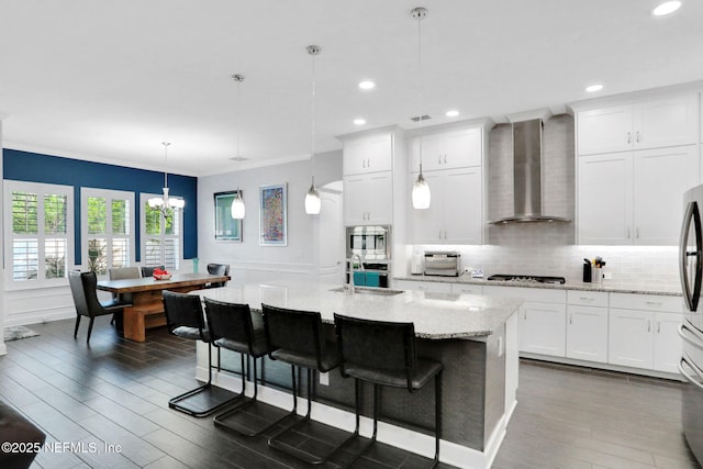 195 Manor Ln, Saint Johns, FL 32259 - kitchen featuring wall chimney exhaust hood, stainless steel appliances, a sink, crown molding, and dark wood-style flooring