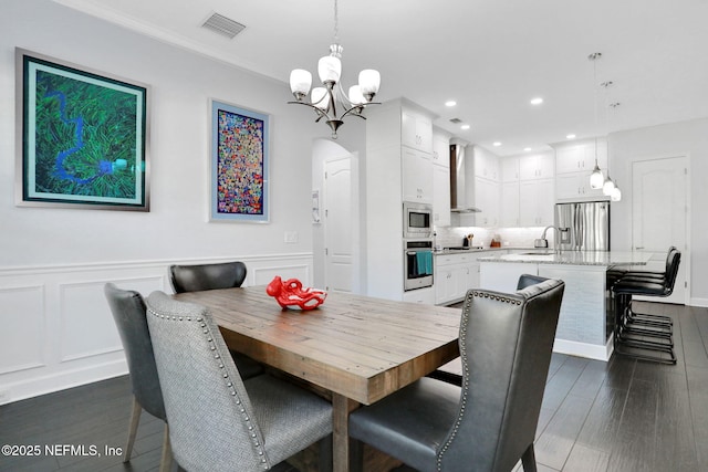195 Manor Ln, Saint Johns, FL 32259 - dining area featuring a chandelier, arched walkways, dark wood-style floors, recessed lighting, and wainscoting