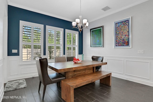 195 Manor Ln, Saint Johns, FL 32259 - dining room with a chandelier, wainscoting, a decorative wall, dark wood-style flooring, and crown molding