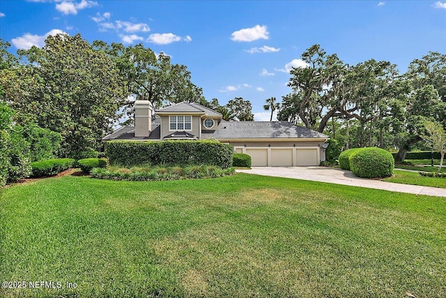 view of front facade with a garage, concrete driveway, and a front yard