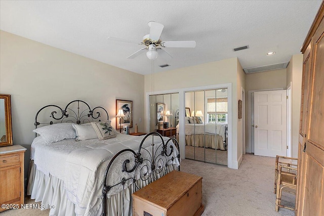 bedroom featuring light carpet, multiple closets, ceiling fan, and recessed lighting