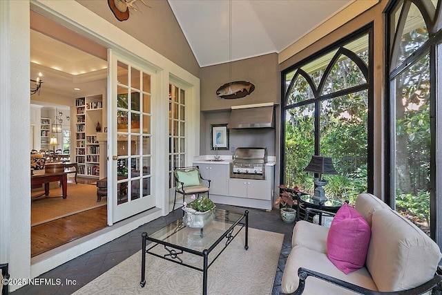sunroom featuring a sink, lofted ceiling, and french doors