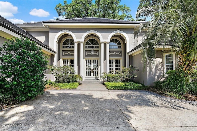 property entrance with french doors and stucco siding