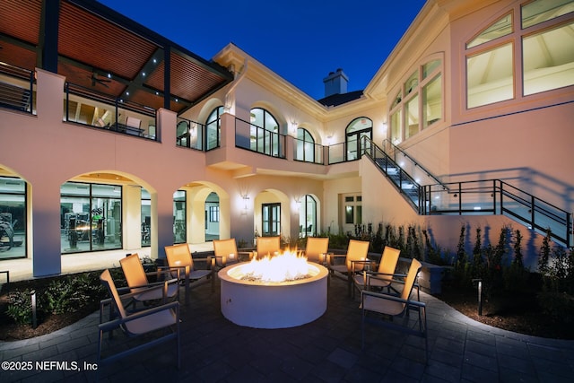 100 Carriage Ct, Ponte Vedra Beach, FL 32082 - patio at night featuring an outdoor fire pit, a patio area, and a balcony