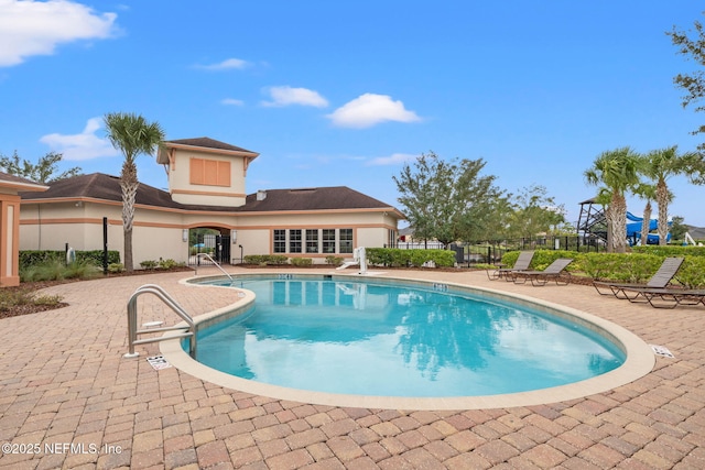 community pool featuring a patio area and fence