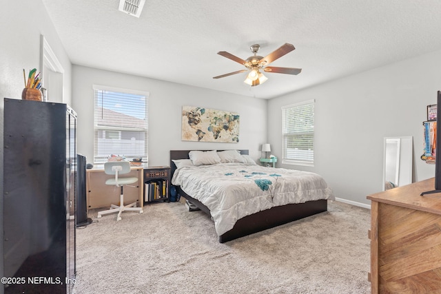 carpeted bedroom with a textured ceiling, a ceiling fan, and baseboards