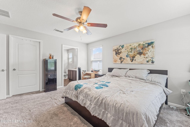 bedroom with carpet, baseboards, ceiling fan, and ensuite bath