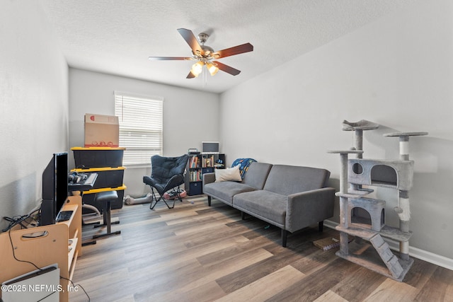 home office with a ceiling fan, wood finished floors, a textured ceiling, and baseboards