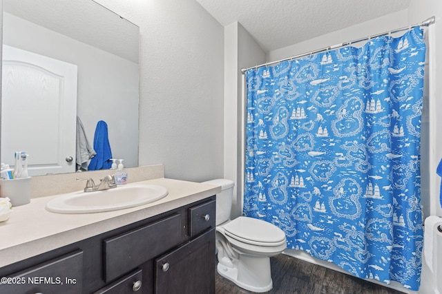 full bath featuring wood finished floors, a textured ceiling, vanity, toilet, and a shower with curtain