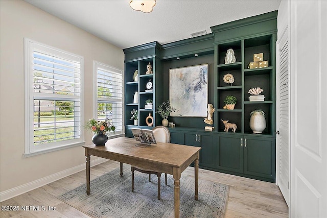 office area with light wood-style floors and baseboards