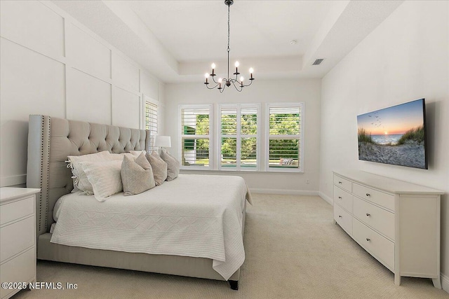 bedroom with a chandelier, a tray ceiling, light carpet, and baseboards