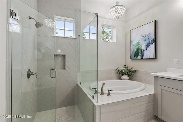 full bathroom featuring a bath, vanity, a shower stall, and a chandelier