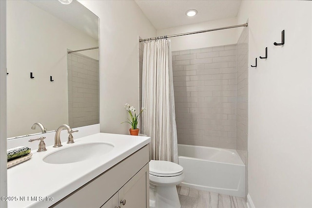 full bathroom featuring toilet, shower / bath combo with shower curtain, and vanity