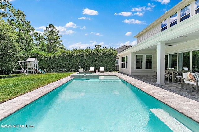 view of swimming pool featuring a yard, a patio area, a playground, and a pool with connected hot tub