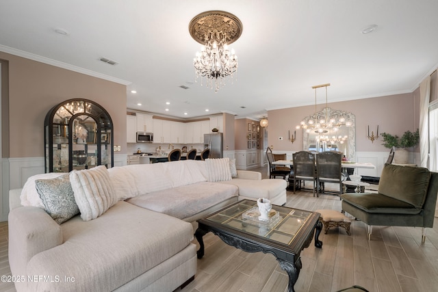 321 Varner Way, Saint Augustine, FL 32092 - living room with a chandelier, ornamental molding, a wainscoted wall, light wood-type flooring, and a decorative wall