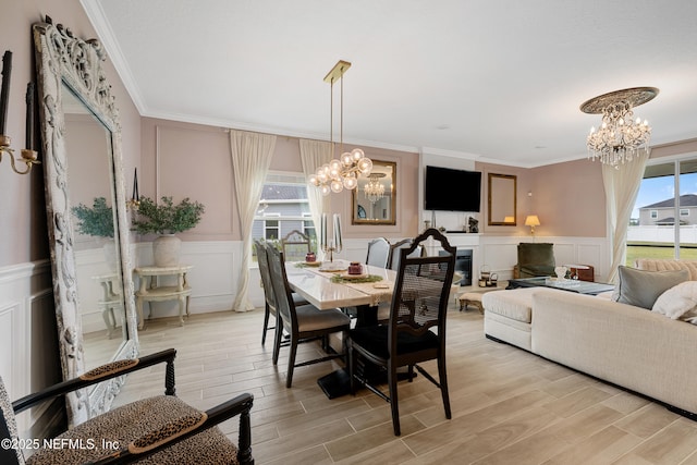 321 Varner Way, Saint Augustine, FL 32092 - dining area featuring a chandelier, a decorative wall, ornamental molding, light wood-style flooring, and wainscoting