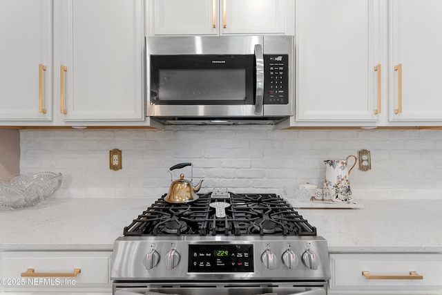 321 Varner Way, Saint Augustine, FL 32092 - kitchen featuring appliances with stainless steel finishes, white cabinets, decorative backsplash, and light stone counters