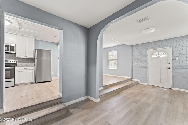 2617 Lake Shore Blvd, Jacksonville, FL 32210 - entrance foyer featuring arched walkways, light wood-style flooring, and baseboards