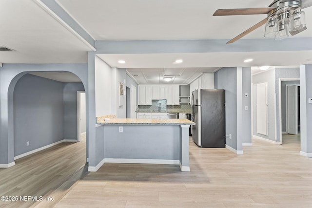 2617 Lake Shore Blvd, Jacksonville, FL 32210 - kitchen with appliances with stainless steel finishes, arched walkways, a sink, light wood-type flooring, and a peninsula