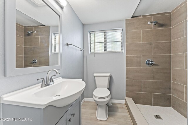 2617 Lake Shore Blvd, Jacksonville, FL 32210 - bathroom with wood finished floors, tiled shower, toilet, vanity, and baseboards