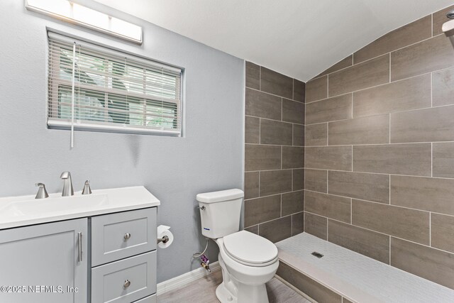 2617 Lake Shore Blvd, Jacksonville, FL 32210 - full bathroom featuring vaulted ceiling, vanity, toilet, tiled shower, and baseboards