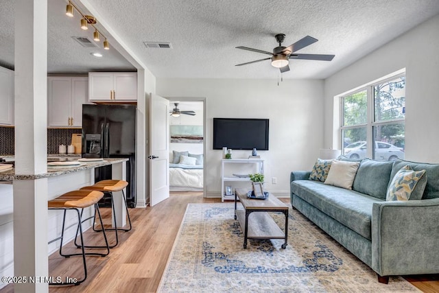 5530 Sharon Ter, Jacksonville, FL 32207 - living room featuring ceiling fan, light wood-type flooring, and a textured ceiling