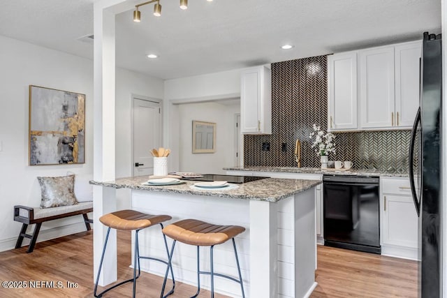 5530 Sharon Ter, Jacksonville, FL 32207 - kitchen featuring black appliances, a kitchen island, light wood-type flooring, white cabinets, and recessed lighting