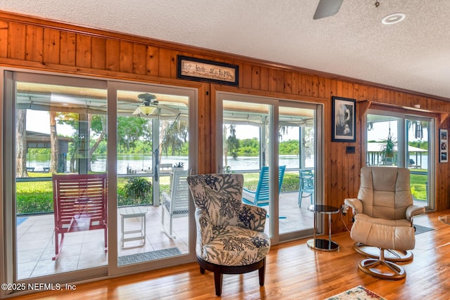 130 Woodbury Trl, Satsuma, FL 32189 - living area with ceiling fan, a water view, a textured ceiling, wood walls, and wood finished floors