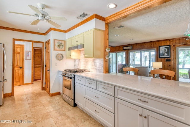 130 Woodbury Trl, Satsuma, FL 32189 - kitchen featuring appliances with stainless steel finishes, under cabinet range hood, decorative backsplash, baseboards, and wooden walls
