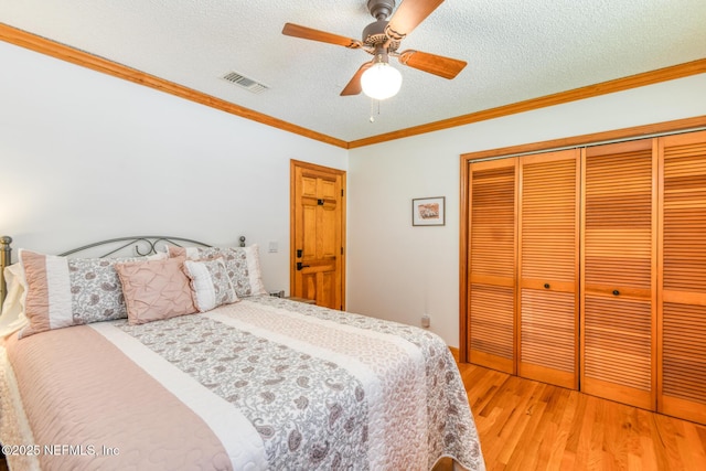 130 Woodbury Trl, Satsuma, FL 32189 - bedroom with light wood-type flooring, a closet, a textured ceiling, crown molding, and a ceiling fan
