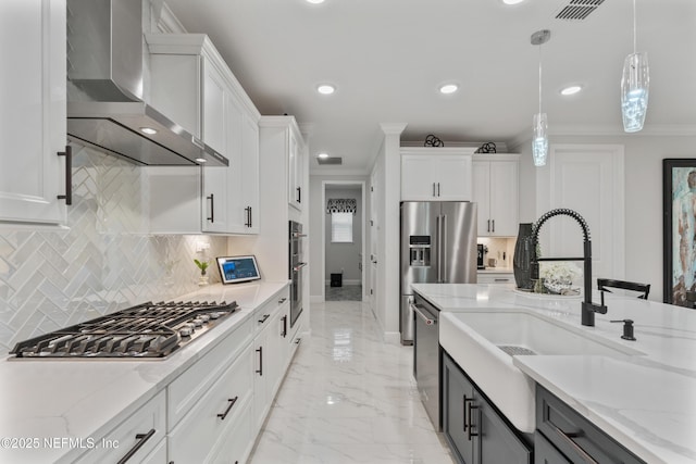 360 Rustic Mill Dr, Saint Augustine, FL 32092 - kitchen featuring appliances with stainless steel finishes, wall chimney range hood, white cabinets, hanging light fixtures, and crown molding