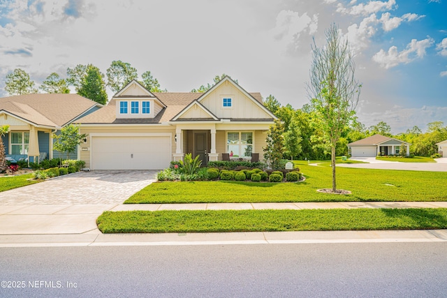 223 Creek Pebble Dr, Ponte Vedra, FL 32081 - craftsman house with decorative driveway, a front yard, an attached garage, and board and batten siding