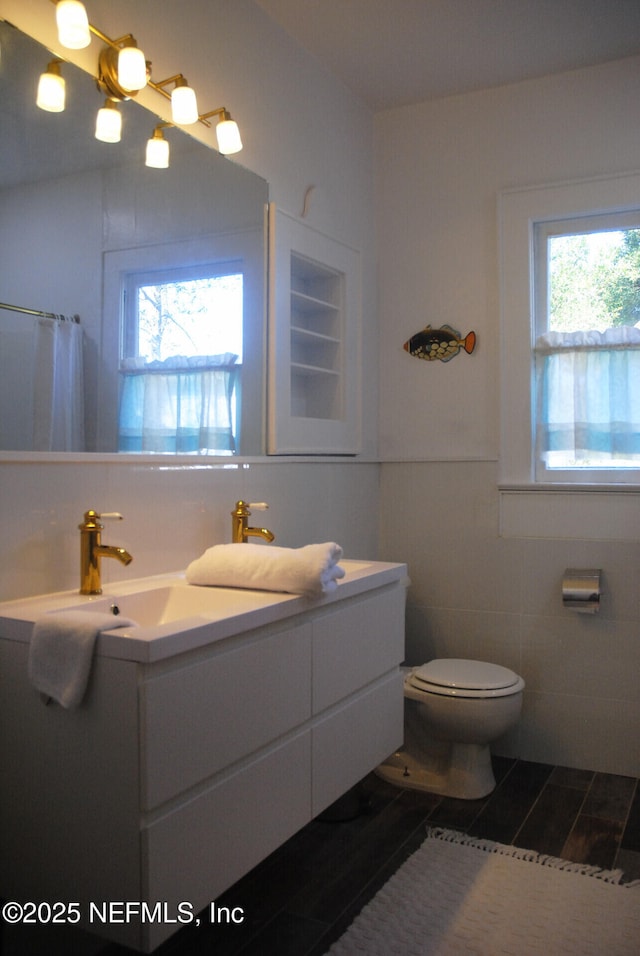 123 Arlington Way, Ormond Beach, FL 32176 - full bath with tile walls, toilet, vanity, a shower with shower curtain, and a wainscoted wall