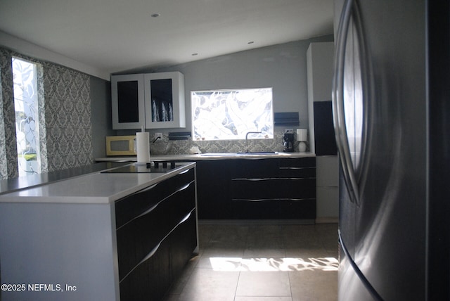 123 Arlington Way, Ormond Beach, FL 32176 - kitchen featuring freestanding refrigerator, modern cabinets, white microwave, light countertops, and dark cabinets