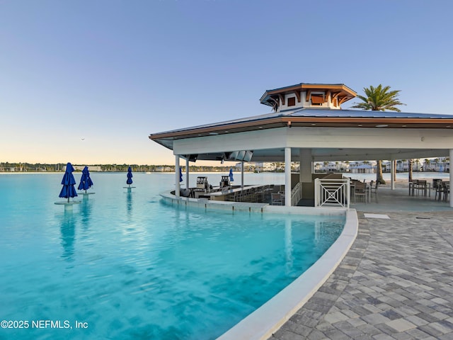 471 Rum Runner Way, Saint Johns, FL 32259 - pool at dusk featuring a gazebo, exterior bar, and a water view