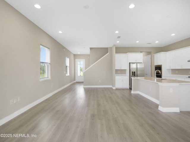 471 Rum Runner Way, Saint Johns, FL 32259 - unfurnished living room with light wood-type flooring, baseboards, recessed lighting, and a sink