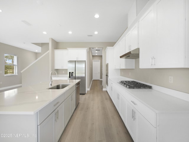 471 Rum Runner Way, Saint Johns, FL 32259 - kitchen with a sink, stainless steel appliances, under cabinet range hood, white cabinets, and light wood-style flooring