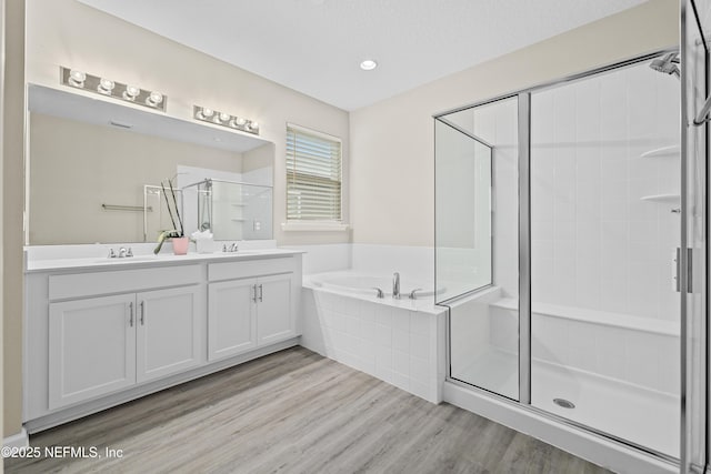 618 Honeycomb Trl, Saint Augustine, FL 32095 - full bathroom with a shower stall, a bath, wood finished floors, double vanity, and recessed lighting