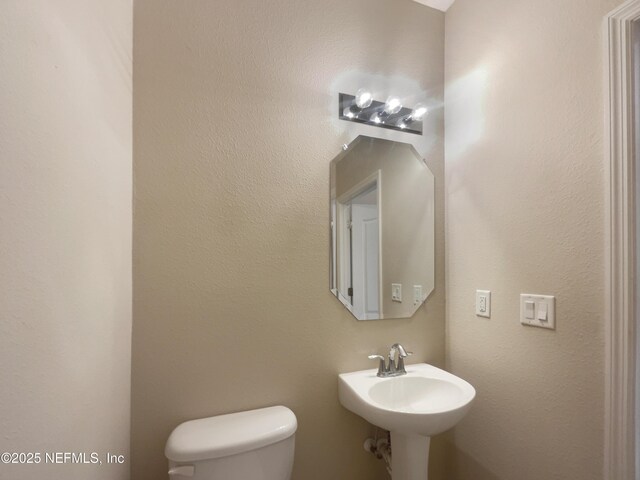 half bath with toilet and a sink