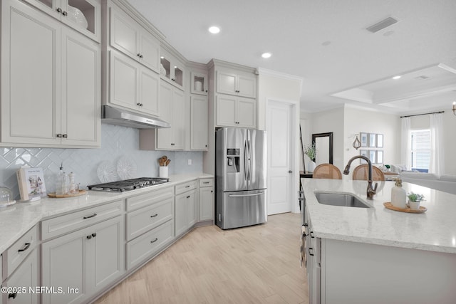 111 Bucktail Ave, Ponte Vedra, FL 32081 - kitchen featuring stainless steel appliances, a sink, under cabinet range hood, light wood-type flooring, and decorative backsplash