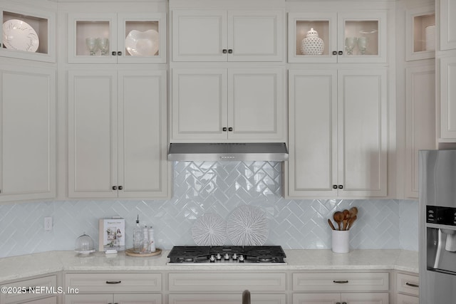 111 Bucktail Ave, Ponte Vedra, FL 32081 - kitchen with stainless steel appliances, under cabinet range hood, white cabinetry, and decorative backsplash