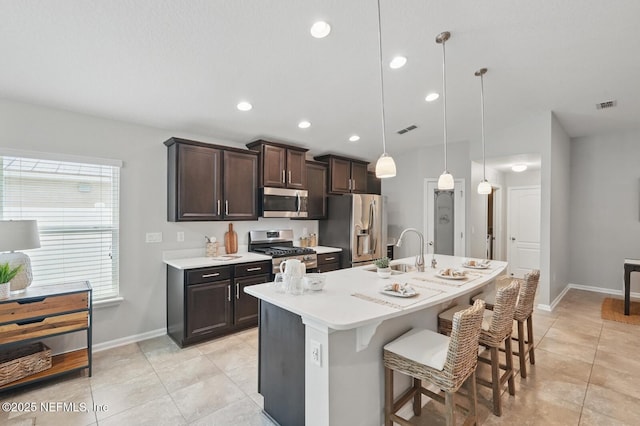 481 Fox Water Trl, Saint Augustine, FL 32086 - kitchen with appliances with stainless steel finishes, a sink, light tile patterned floors, dark brown cabinets, and light countertops