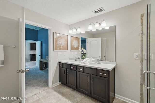 481 Fox Water Trl, Saint Augustine, FL 32086 - ensuite bathroom featuring double vanity, a textured ceiling, baseboards, and tile patterned floors