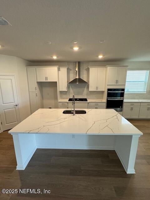 317 Archstone Way, Saint Augustine, FL 32092 - kitchen featuring wall chimney range hood, a sink, a center island with sink, recessed lighting, and dark wood-style flooring