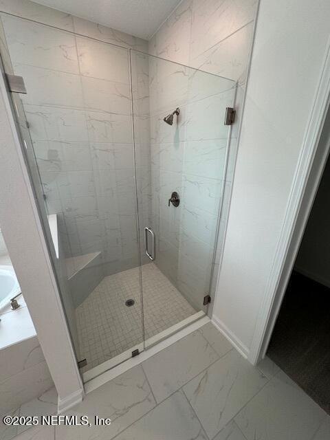 317 Archstone Way, Saint Augustine, FL 32092 - bathroom with marble finish flooring, a shower stall, a bath, and baseboards