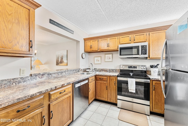 8550 A1A S Unit 14151, Saint Augustine, FL 32080 - kitchen featuring stainless steel appliances, a sink, light tile patterned floors, a textured ceiling, and brown cabinetry