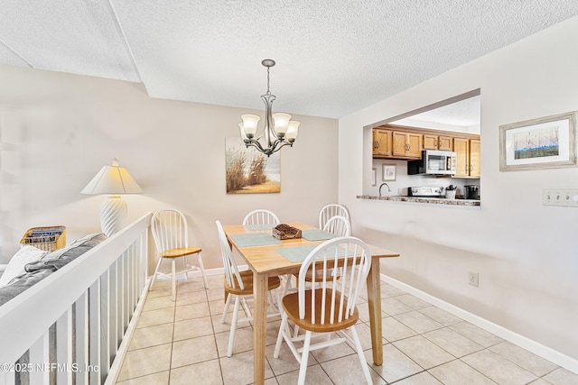 8550 A1A S Unit 14151, Saint Augustine, FL 32080 - dining area with light tile patterned flooring, a chandelier, a textured ceiling, and baseboards
