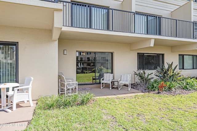 8550 A1A S Unit 14151, Saint Augustine, FL 32080 - entrance to property featuring a balcony, stucco siding, a lawn, and a patio